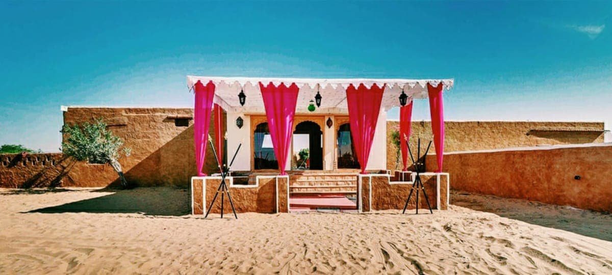 Explore Overnight Desert Camp Jaisalmer entrance under a clear Thar sky